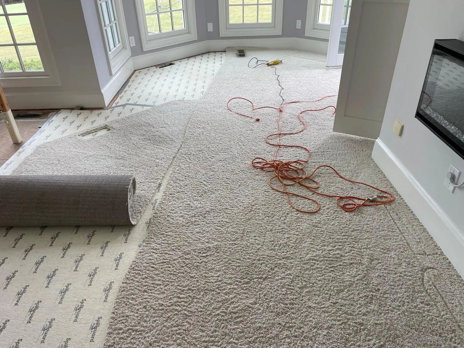 Old carpet being pulled up from the living room floor before the hardwood installation