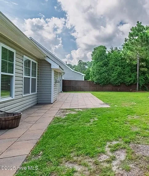 Finished backyard paver patio next to a green lawn in Wilmington, NC