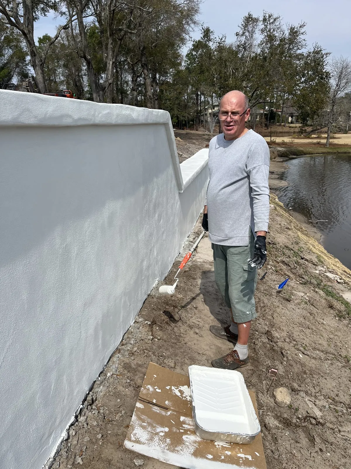 Yurii rolling fresh paint onto the exterior wall
