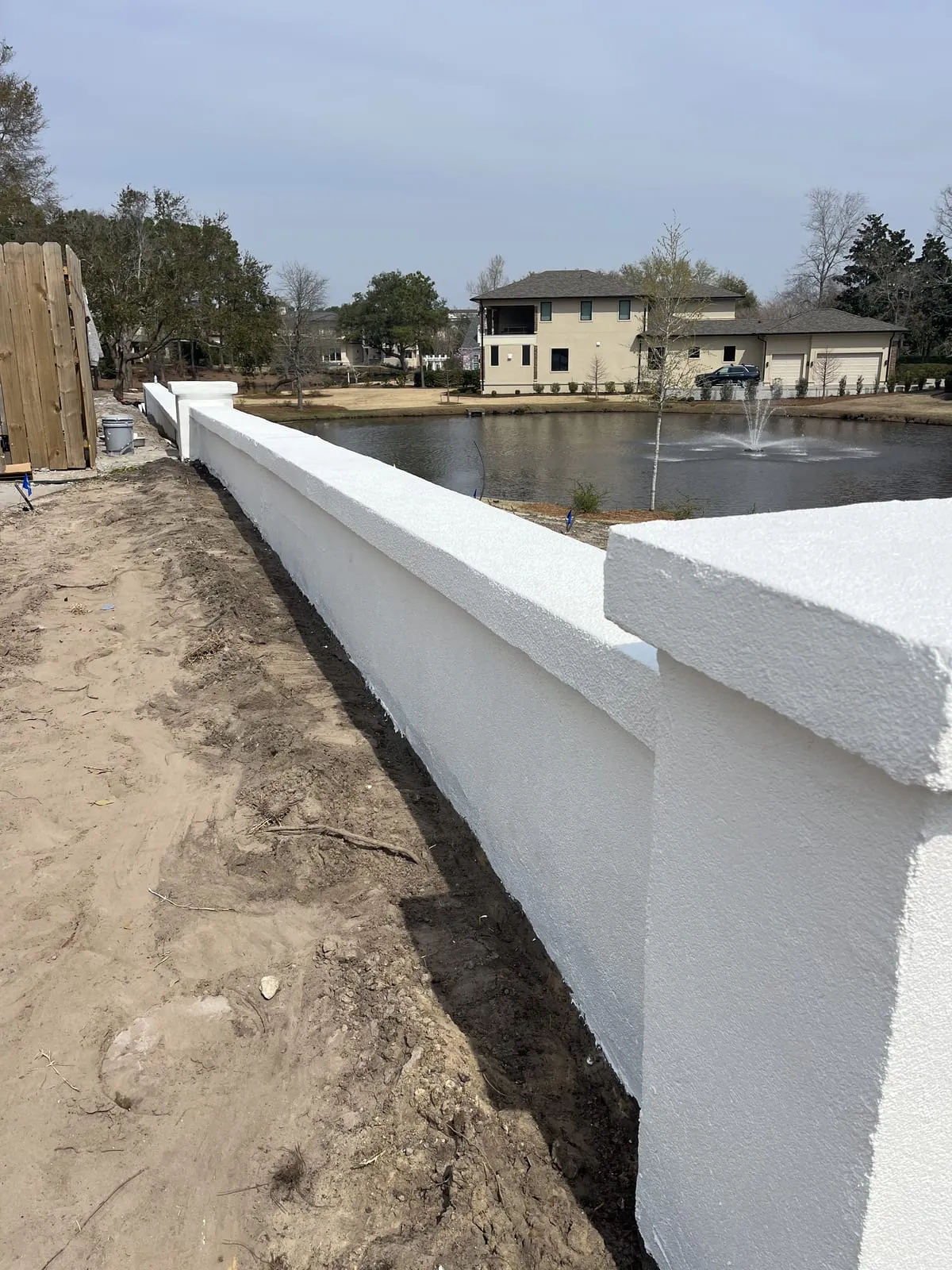 Freshly painted white exterior wall beside a pond in Wilmington, NC